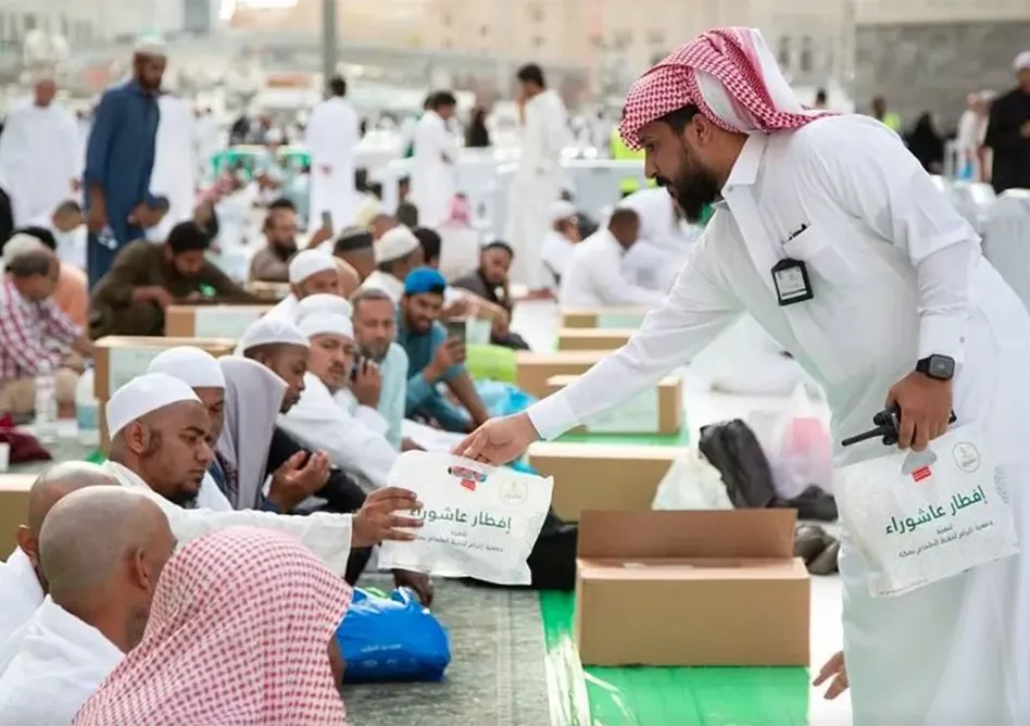 A person handing out Iftar food packages